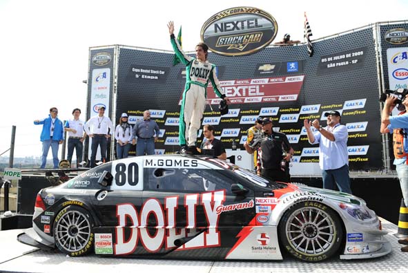 dm_07.07_stock_marcosgosmes_WE Marcos Gomes festeja a vitória em Interlagos no teto do seu Stock Car, que horas depois seria destruído pelo fogo; Paulo Gomes (de camida branca), Paulo de Tarso (de uniforme preto) e Pedro Gomes participam da festa (Foto Fernanda Freixosa/Agência WE)